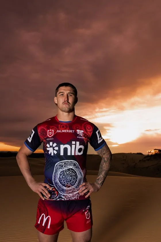 A male player in the jersey under a cloud-streaked sky