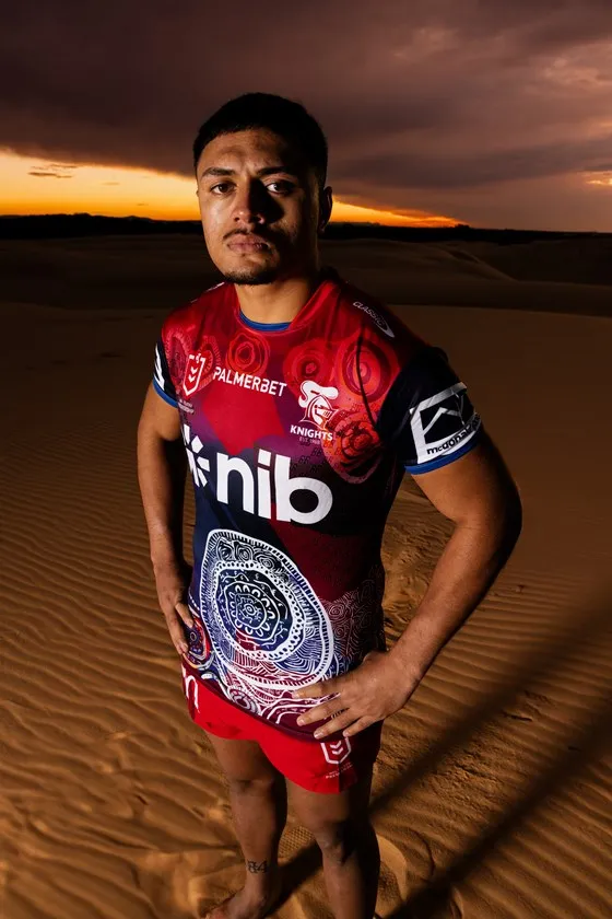 A male player on the dune ridge in the Indigenous jersey