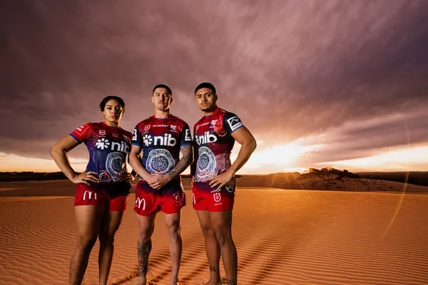 The same three players on the dune, wider