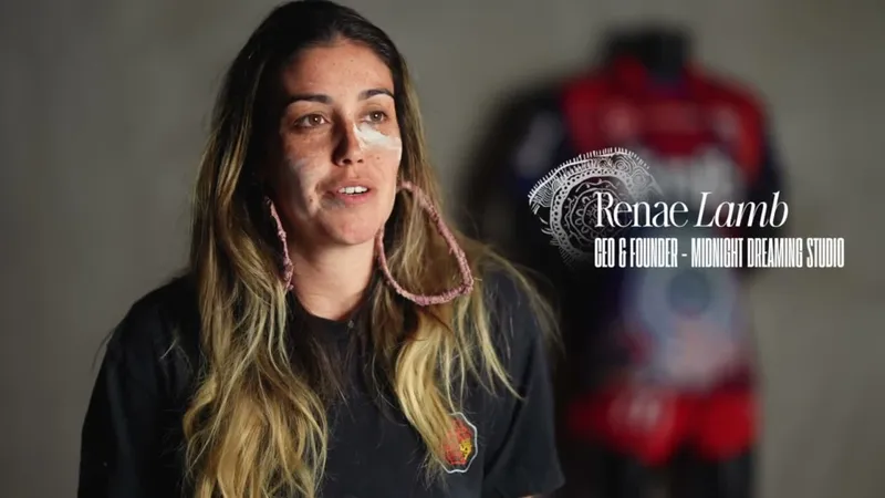 Renae Lamb speaking to camera with the Nginhabulagu jersey on a mannequin behind her