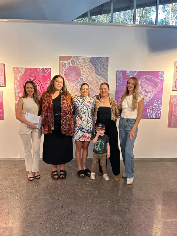 Five women and a child in front of Renae Lamb’s hung works