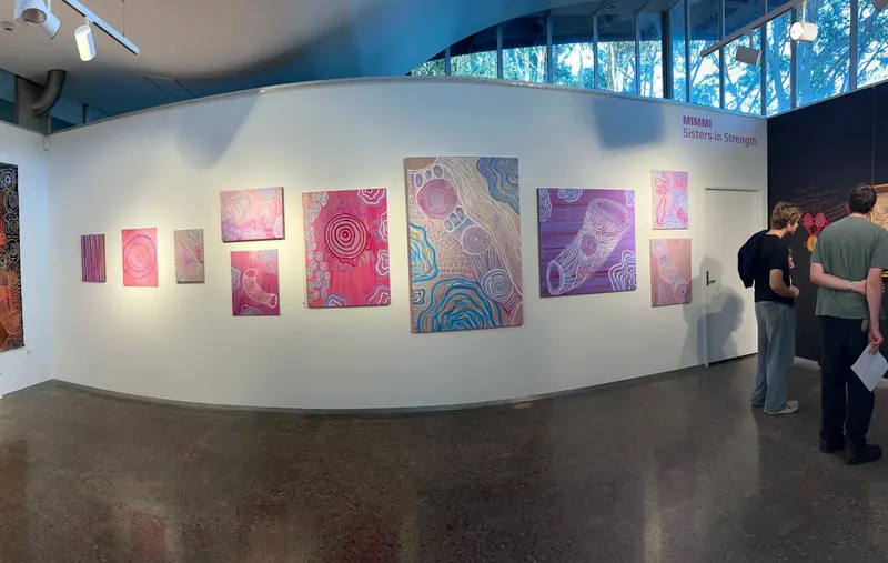 A full hang of Renae Lamb’s pink works with visitors in the space