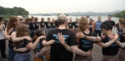Ma & Morley Scholars standing in a circle by the water