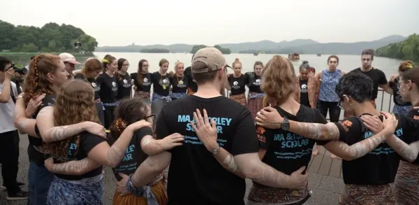 Ma & Morley Scholars standing in a circle by the water