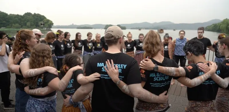 Ma & Morley Scholars standing in a circle by the water