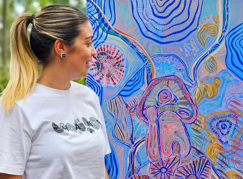 Renae Lamb beside her blue contour-line painting