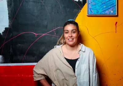 Renae Lamb in front of a mural in progress