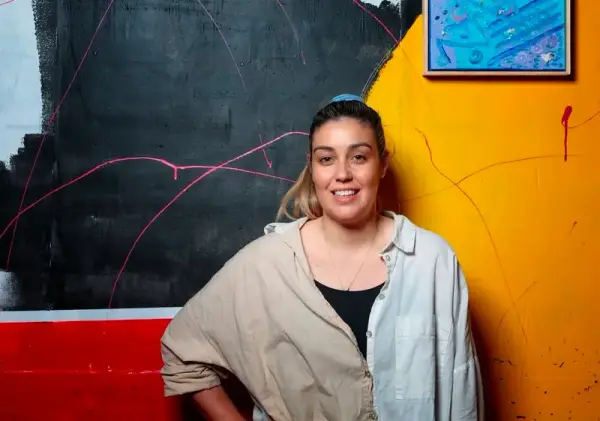 Renae Lamb in front of a mural in progress