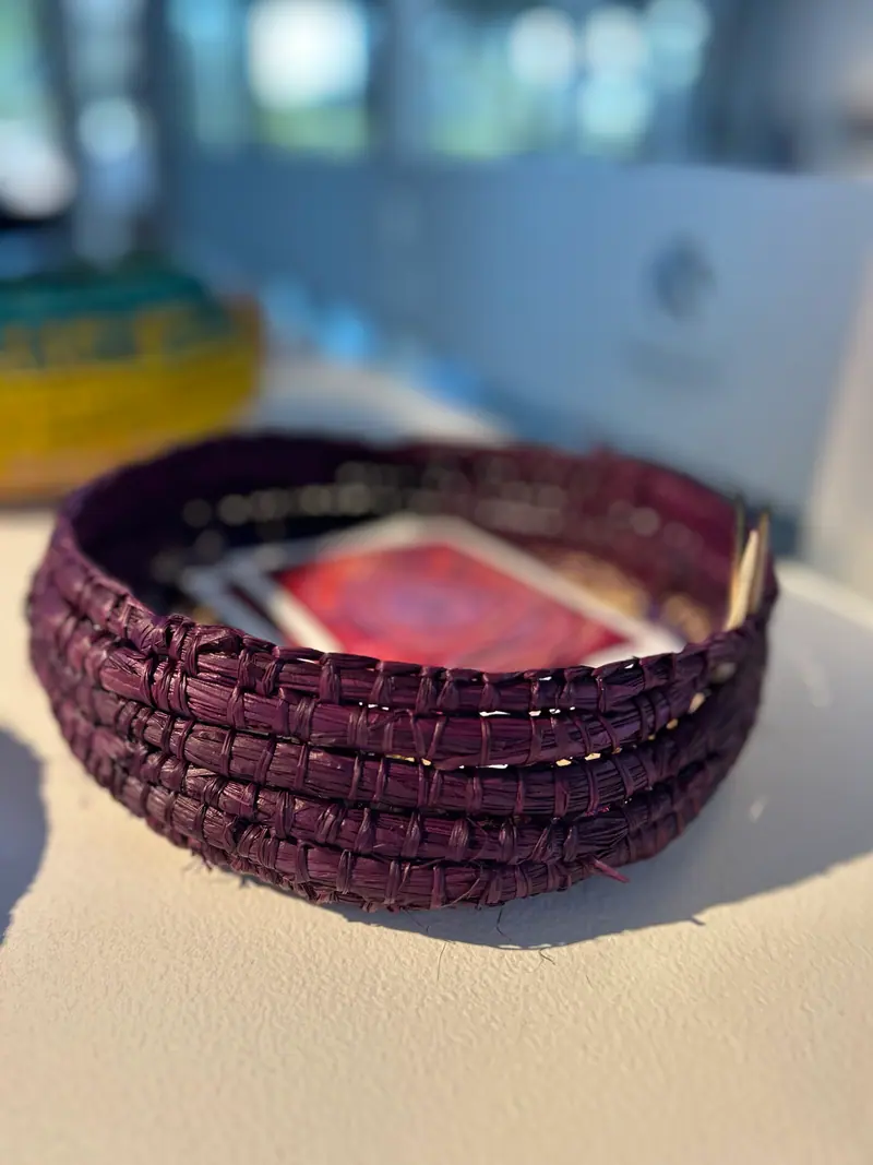 Coiled woven vessel by Renae Lamb in burgundy raffia