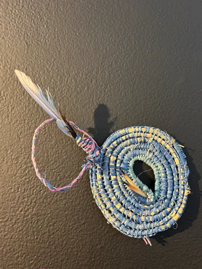 Coiled weaving by Renae Lamb with an emu feather, close