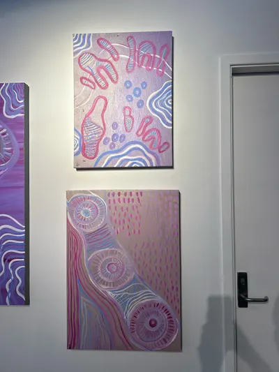 Three paintings by Renae Lamb hung together — pink and lilac